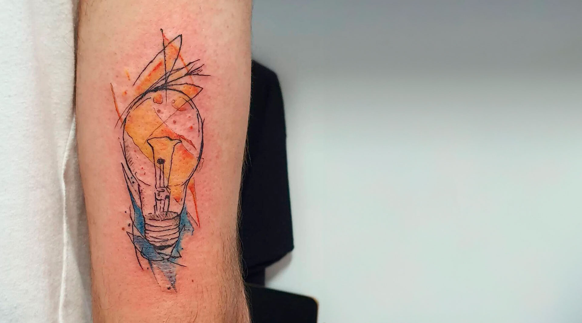 Tatuaggio color lampadina sul braccio